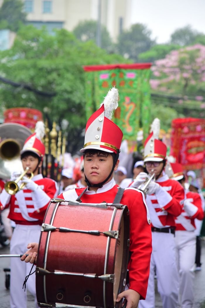 Energetic marching band performing with vibrant uniforms in an outdoor parade.